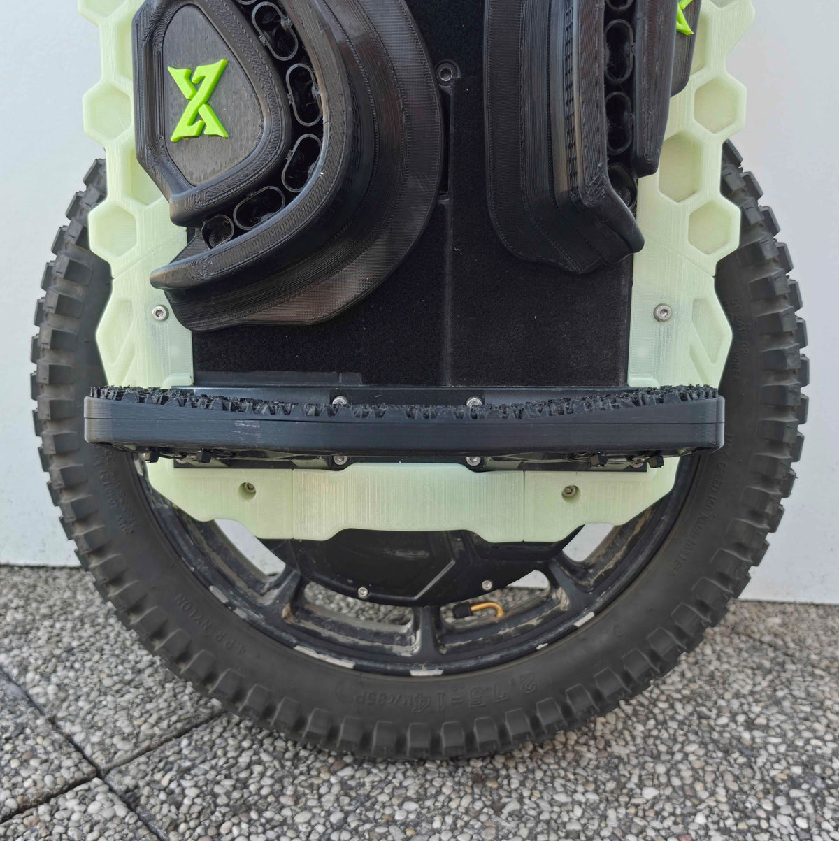Pédale N-Grip déployée sur toute la largeur de la roue, vue de face au-dessus du pneu cranté.