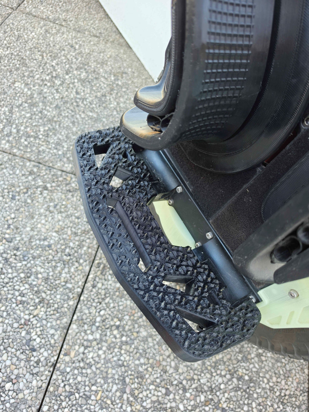 Pédale N-Grip vue de dessus, dépliée le long de la roue, surface à picots profonds.