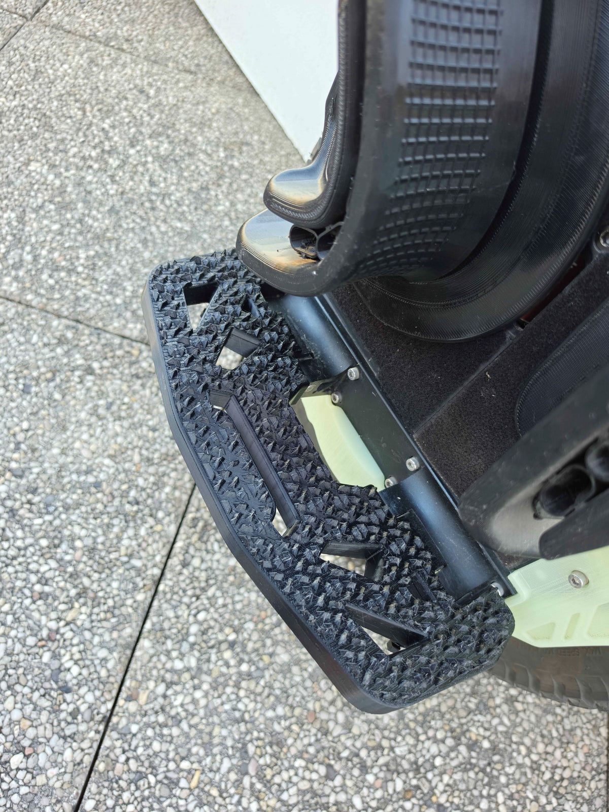 Pédale N-Grip vue de dessus, dépliée le long de la roue, surface à picots profonds.