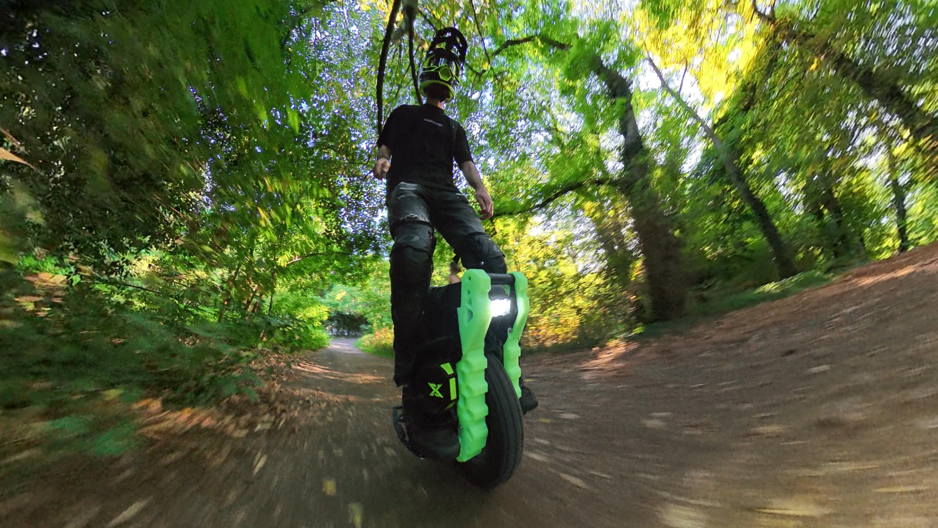 Rider on a Leaperkim Lynx OG protected by the IXEZED kit, side view on a wooded trail